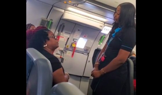 A passenger argues with a flight attendant on a Frontier Airlines flight.