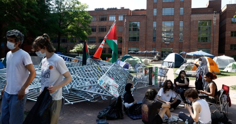 Pro-Palestinian protesters sit outside their tents in an encampment at University Yard at George Washington University in Washington, D.C., on Monday.