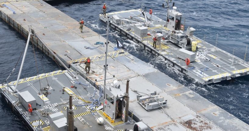 Soldiers assigned to the 7th Transportation Brigade and sailors attached to the MV Roy P. Benavidez assemble the Roll-On, Roll-Off Distribution Facility. or floating pier, off the shore of Gaza in the Mediterranean Sea on April 26.