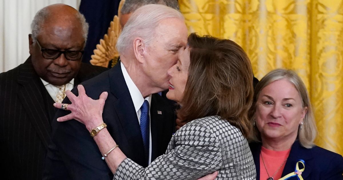 Joe Biden kissing Nancy Pelosi during a White House event