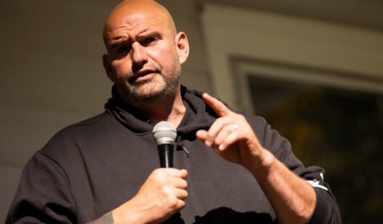 Sen. John Fetterman peaks at a campaign event held for Pennsylvania judicial candidates at Snipes Farm in Morrisville, Pennsylvania, on Oct. 28.
