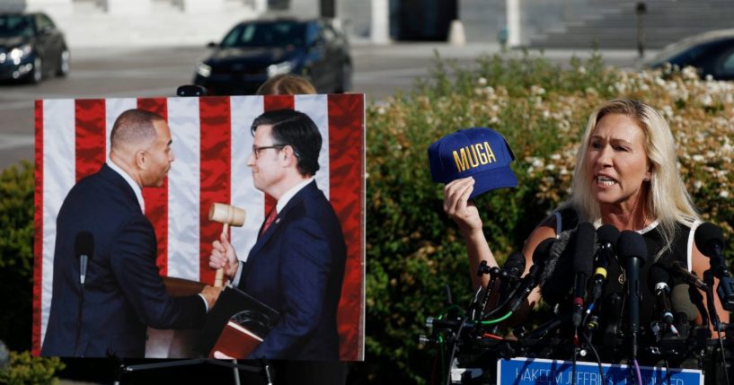 Rep. Marjorie Taylor Greene holds up a "Make Ukraine Great Again" hat while speaking from the steps of the U.S. Capitol in Washington, D.C., on Wednesday, announcing when she will call for the removal of Speaker of the House Mike Johnson.