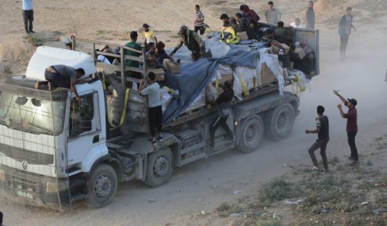 Palestinians rush trucks as they transport international humanitarian aid from the US-built Trident Pier in the central Gaza Strip on Saturday.