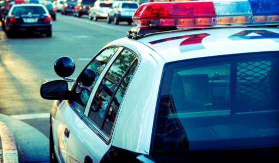 This stock image shows a police car parked on a city street.