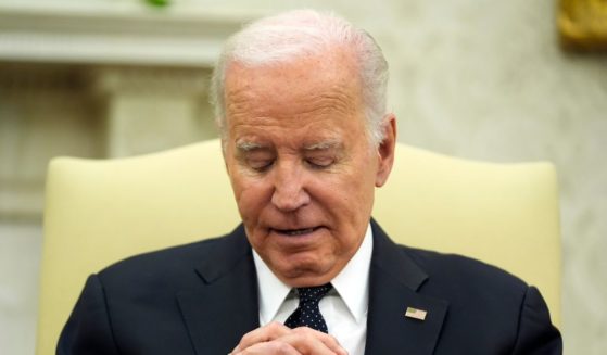 Joe Biden listening to Romania's President Klaus Iohannis in the Oval Office