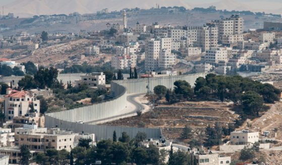 This image shows an overview into the West Bank and a view of the wall separating East Jerusalem as viewed from the Mount of Olives.