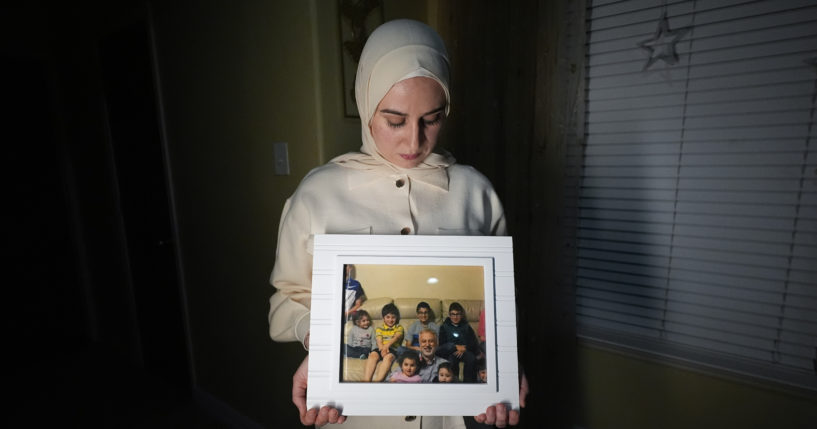 Maryam Kamalmaz hold a photo of her father with some of his 14 grandchildren in Grand Prairie, Texas, in a file photo from Jan. 17. U.S. officials have developed intelligence suggesting that Majd Kamalmaz, an American citizen who disappeared seven years ago while traveling in Syria has died,