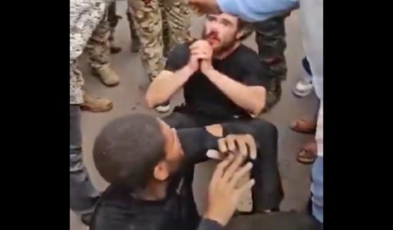 Two man sit on the ground surrounded by Congolese soldiers after a coup attempt Sunday in Kinshasa, the capital of the Democratic Republic of Congo.