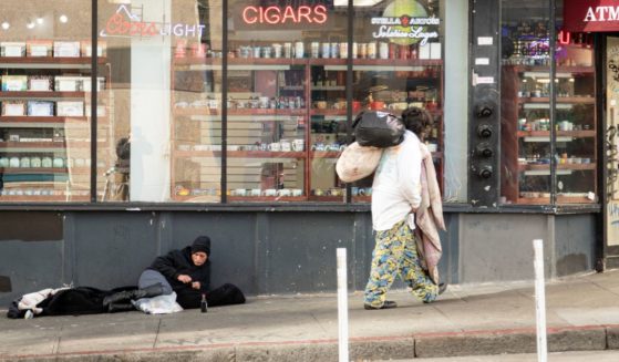 A person lies on the sidewalk in San Francisco, on November 13, 2023.