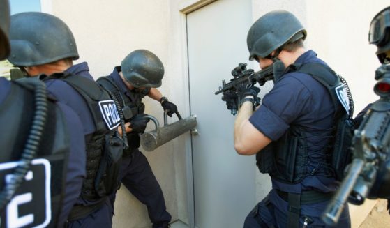 This Getty stock image depicts police breaking down a door.