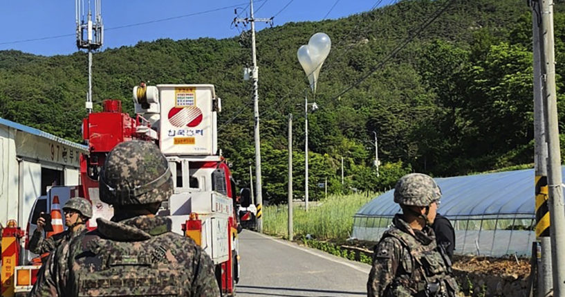 Balloons with trash, presumably sent by North Korea, hang on electric wires as South Korean army soldiers stand guard in Muju, South Korea, on Wednesday. North Korea launched more trash-carrying balloons toward the South after a similar campaign earlier in the week, according to South Korea's military, in what Pyongyang calls retaliation for activists flying anti-North Korean leaflets across the border.