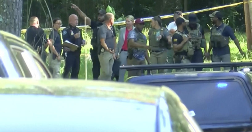 Law enforcement officers arrive at a wooded area on Thursday, June 13, 2024 in Jackson, Mississippi. A Louisiana woman was found dead in her home Thursday, and her two young daughters were abducted and found hours later in Mississippi -- One dead and the other alive, police said.