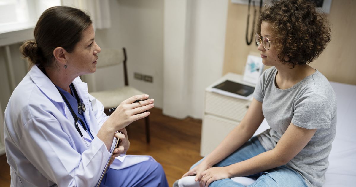 This image shows a doctor talking with her young female patient.