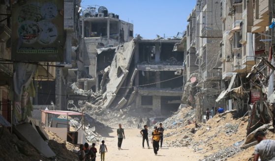 Palestinians walk past buildings destroyed in the Israeli bombardment of Khan Yunis in the southern Gaza Strip on Tuesday.