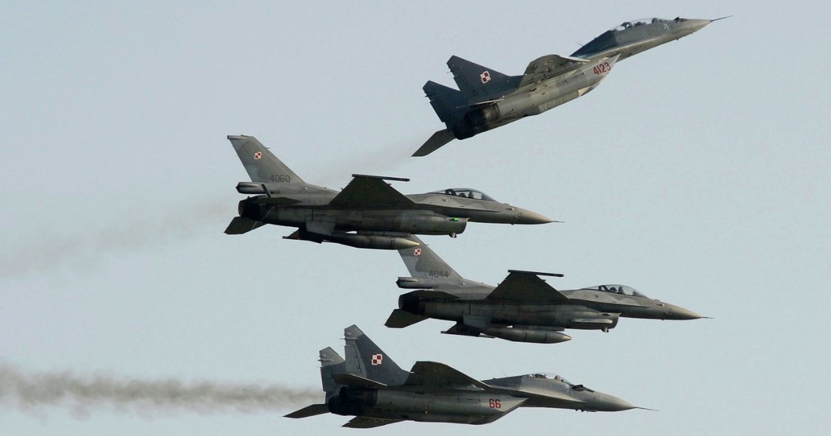 four Polish fighter jets flying during an air show