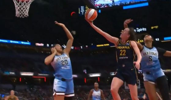 Angel Reese of the Chicago Sky fouls Caitlin Clark of the Indiana Fever.