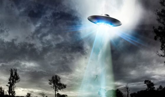 This stock illustration depicts a UFO beaming up a human.