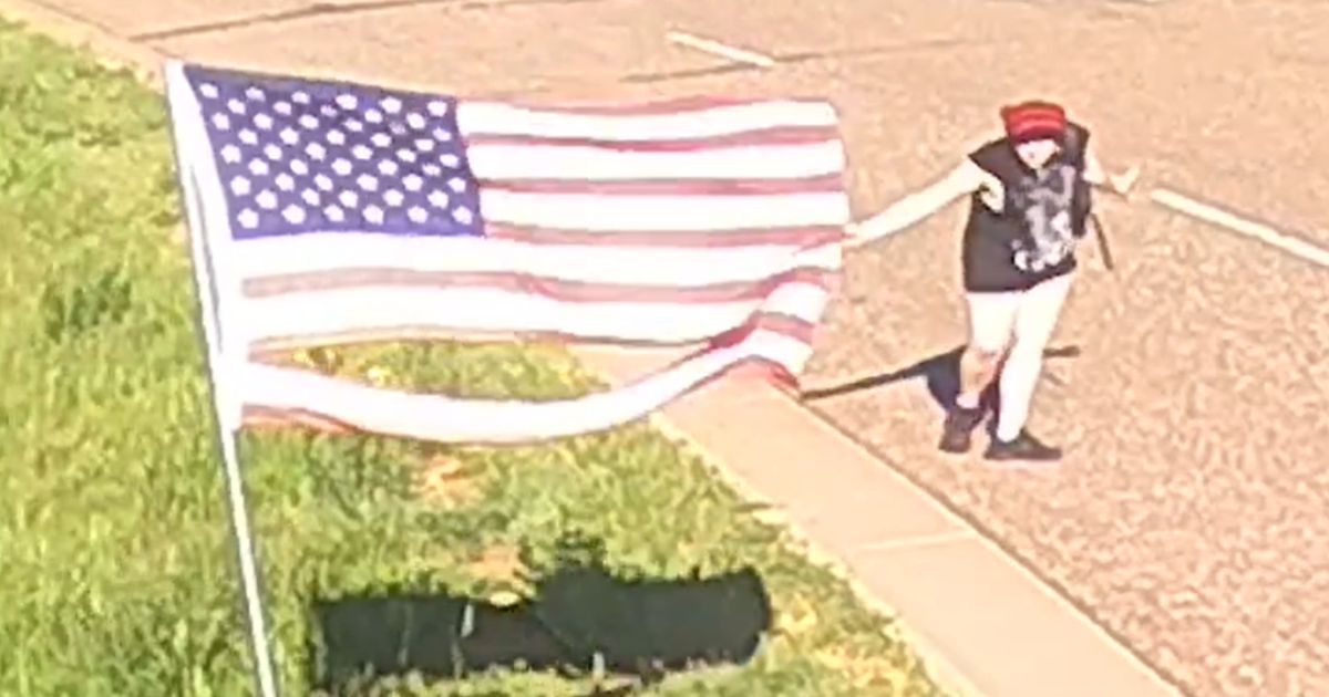 A woman curtsied as she ripped up an American flag surrounding police headquarters in Golden, Colorado on June 5.