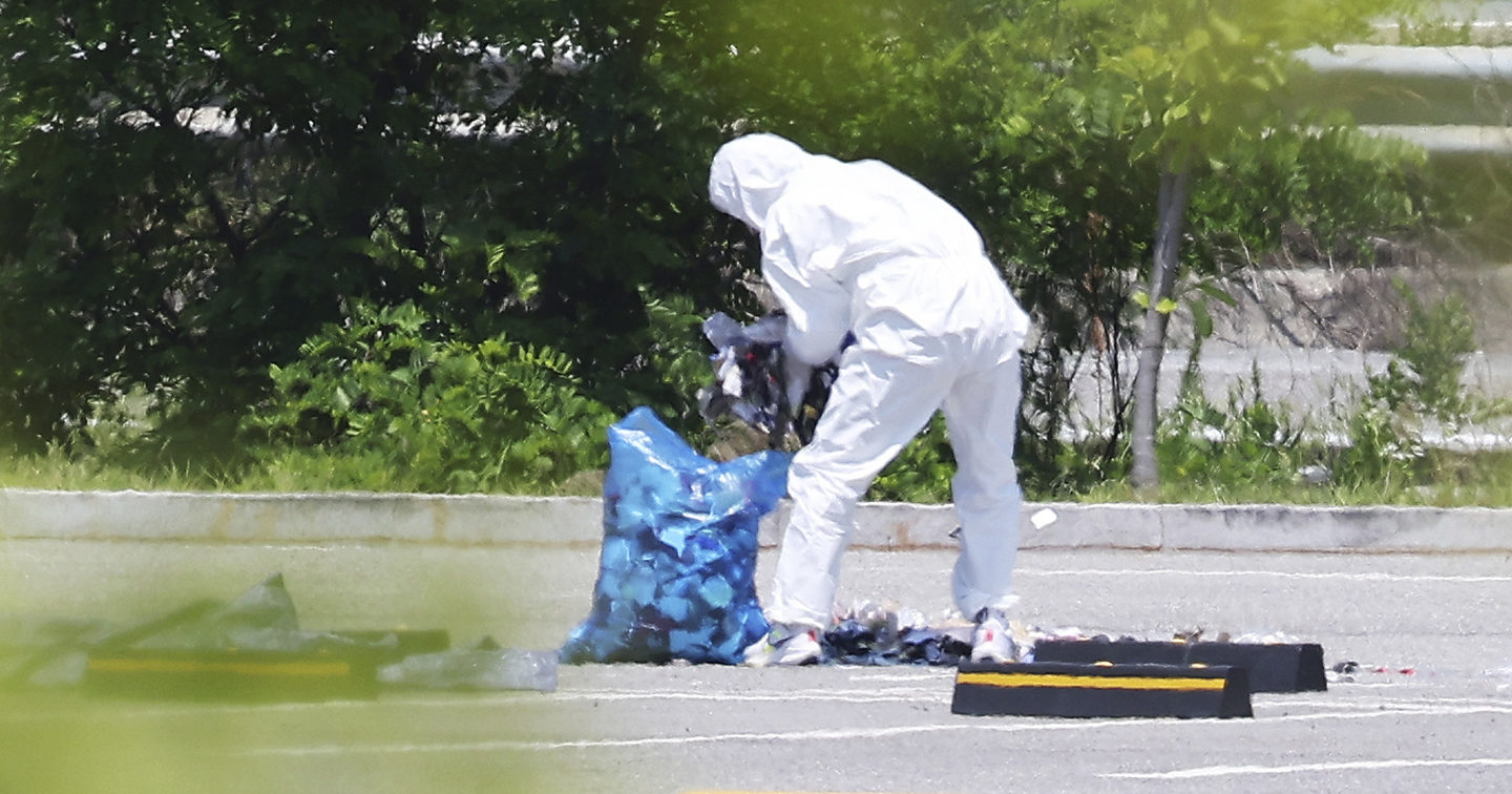 An officer wearing protective gear collects the trash from a balloon presumably sent by North Korea, in Siheung, South Korean, Sunday, June 2, 2024.