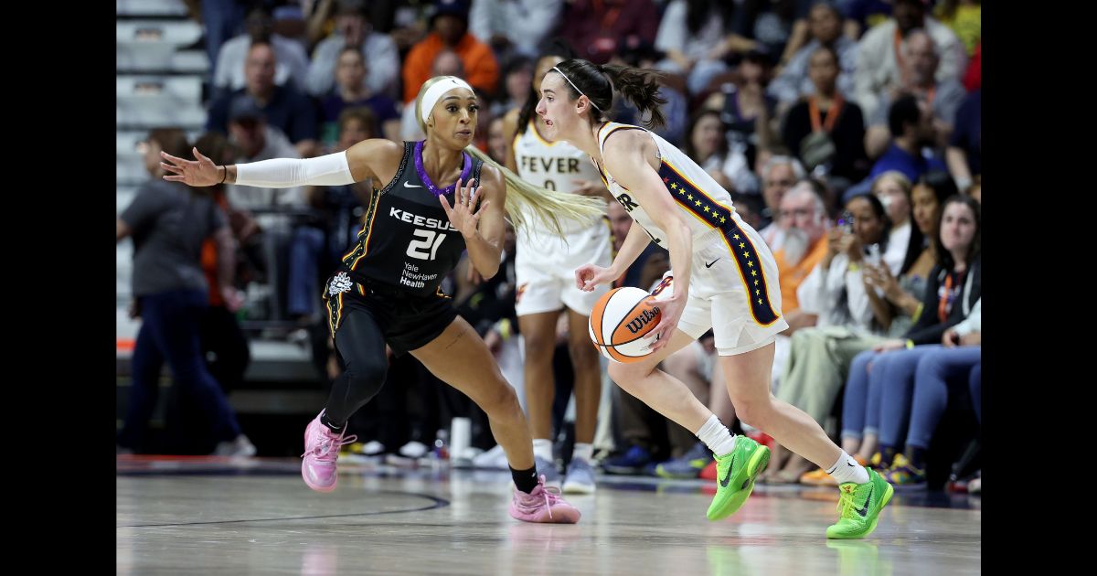 Caitlin Clark #22 of the Indiana Fever dribbles the ball against DiJonai Carrington #21 of the Connecticut Sun during the second quarter in the game at Mohegan Sun Arena on May 14, 2024 in Uncasville, Connecticut.