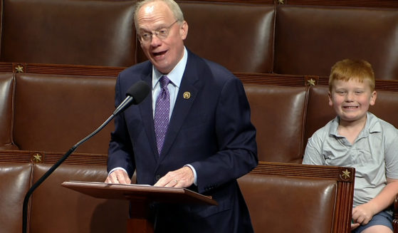 Rep. John Rose speaks on the floor of the House of Representatives in Washington, D.C., on Monday, as his son Guy smiles behind.