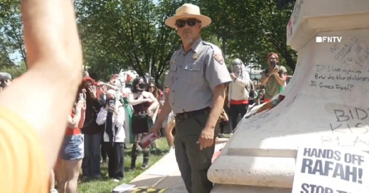 A National Park Service ranger faces a mob of pro-Palestinian demonstrators on Saturday in Lafayette Square in Washington, D.C.