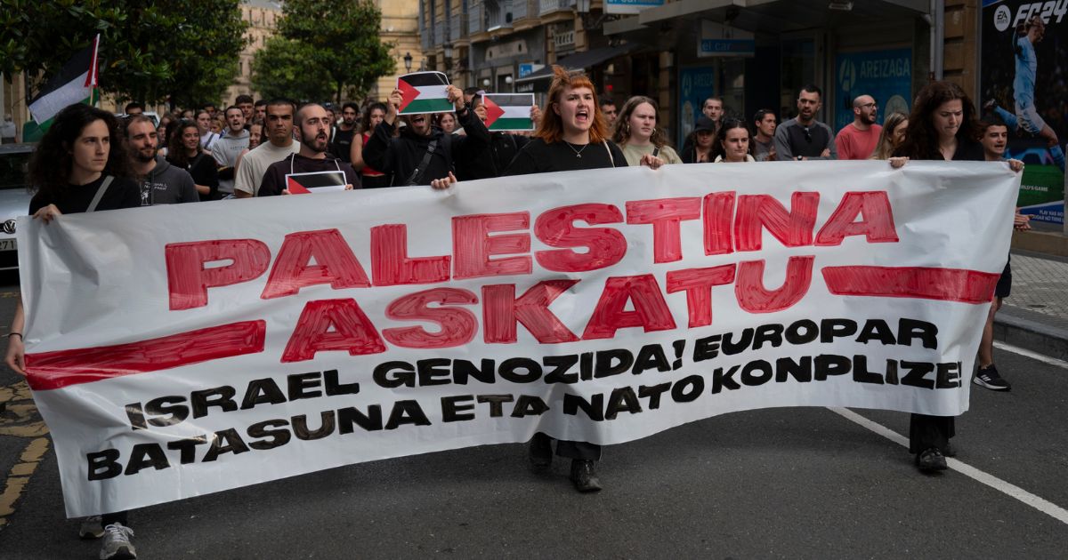 Pro-Palestinian youth wearing a banner reading 'Free Palestine, Genocidal Israel, European Union and NATO complicit' shout slogans at a demonstration in support of the Palestinians and the Gaza strip on June 6, 2024 in San Sebastian, Spain.